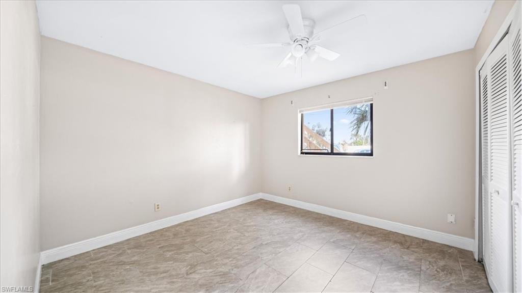 Neutral-toned walls, tile flooring, and a ceiling fan