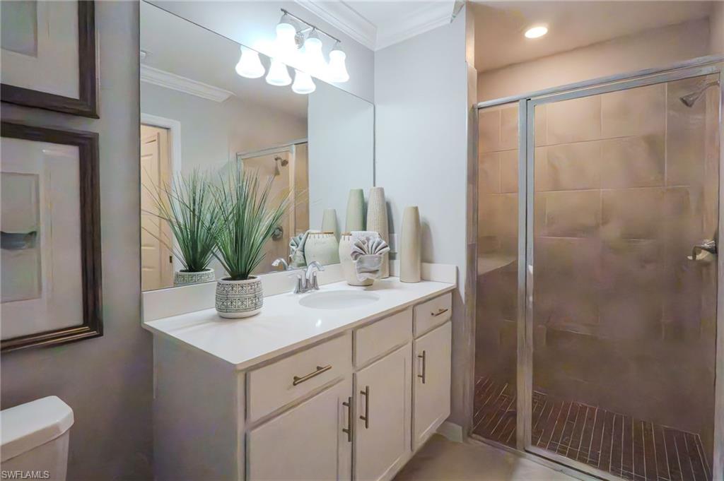 White vanity with integrated sink, chrome faucet, and gold-tone hardware