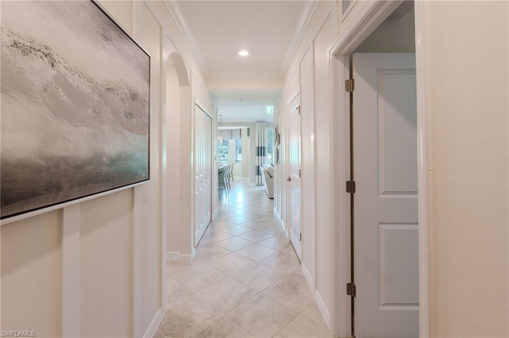 Tiled flooring, recessed lighting, arched doorway, panel wall accents, and interior doors