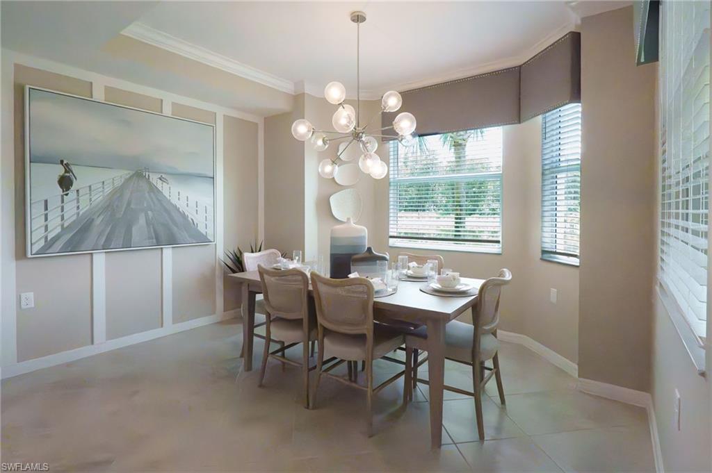 Dining area featuring a modern chandelier, bay window with blinds, panel molding, and tile flooring