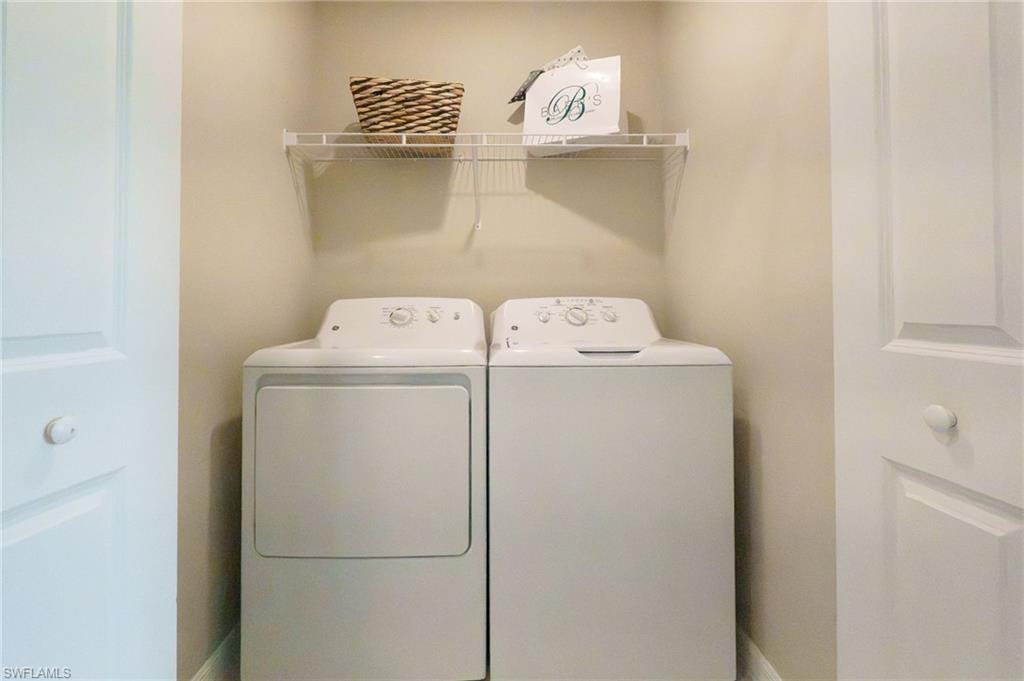 Laundry area featuring neutral wall paint, a wire shelf, and white paneled doors with matching knobs