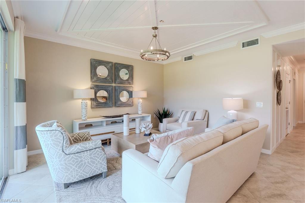 Coffered ceiling with wood paneling, contemporary chandelier, sliding glass door, and neutral wall tones