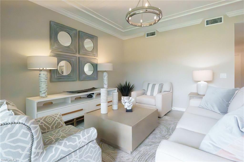 Tray ceiling with crown molding, recessed lighting, and a chandelier