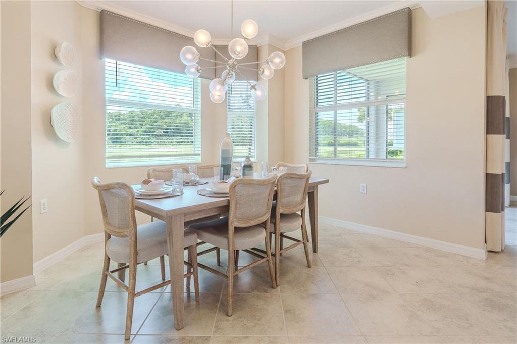 Neutral-toned wall paint, large windows, crown molding, and tiled flooring
