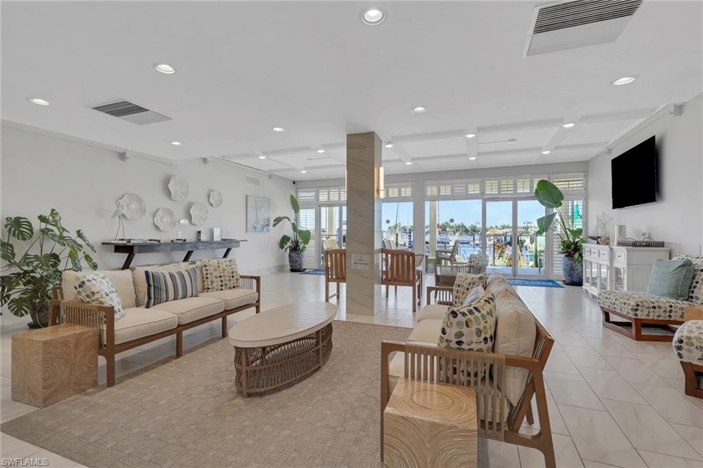 Recessed lighting and a coffered ceiling illuminate an expansive interior space with tile flooring