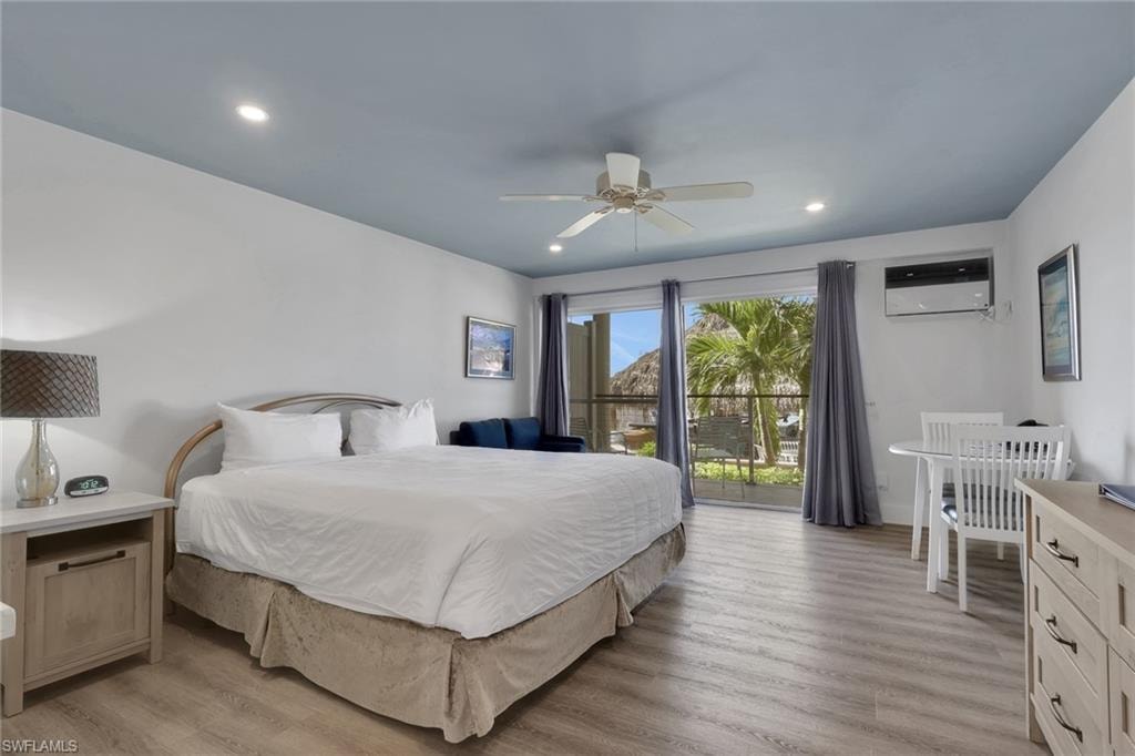 Light wood-finish flooring, recessed lighting, ceiling fan, and sliding glass doors with direct outdoor access