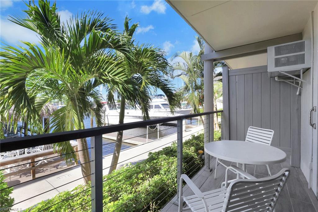 Balcony with cable railing, wood-look flooring, and a private outdoor unit