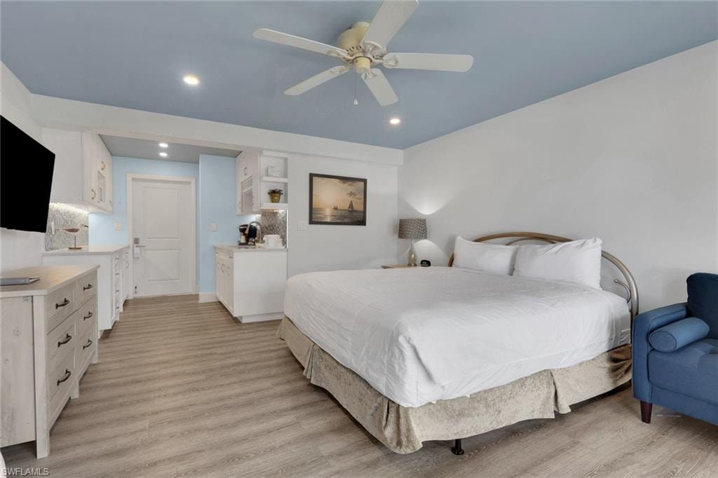 Wood-finish flooring, recessed lighting, ceiling fan, built-in cabinetry, and integrated kitchenette