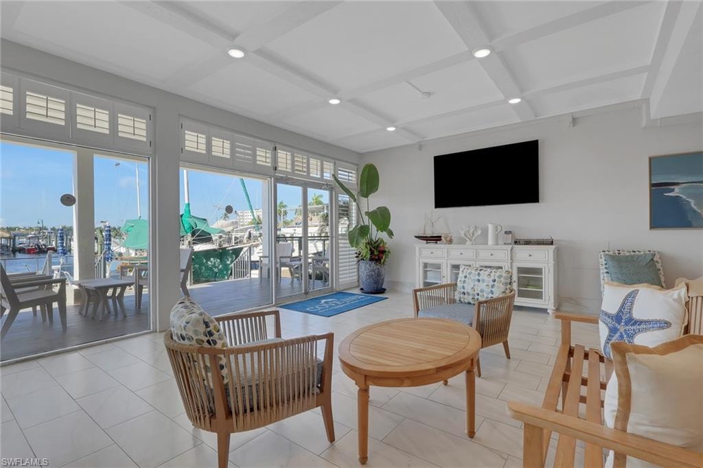 Expansive glass sliding doors with transom windows, coffered ceiling, recessed lighting, and tile flooring