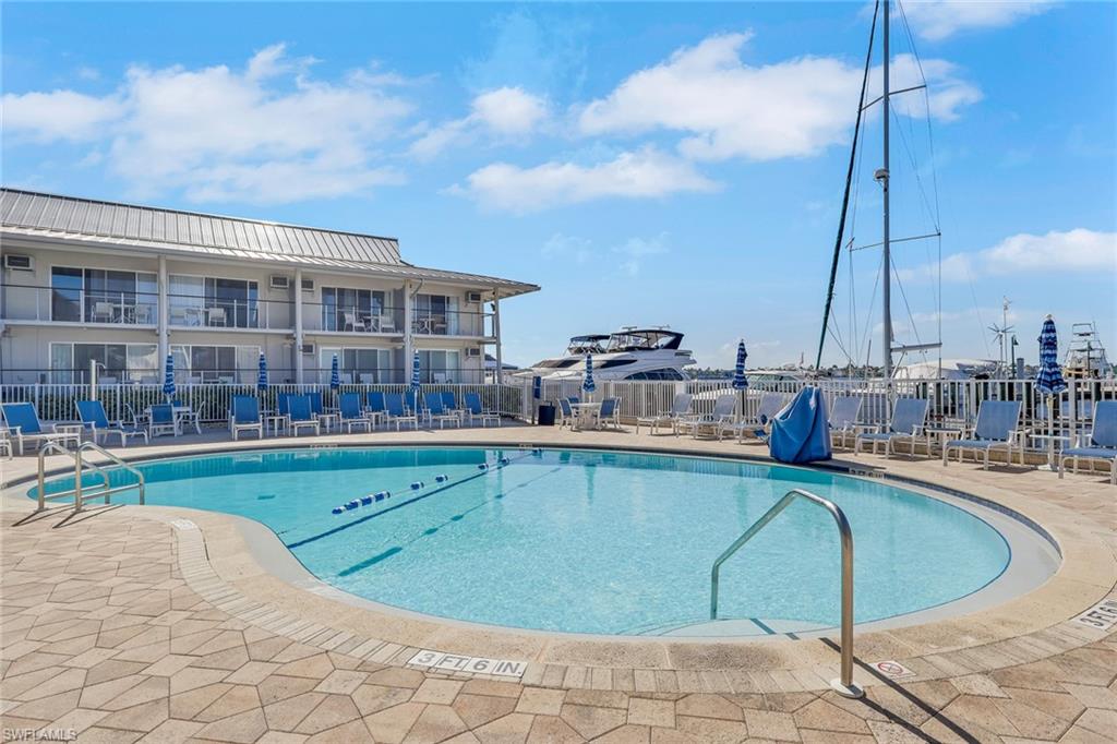 Outdoor swimming pool with integrated steps, paver decking, and surrounding lounge chairs