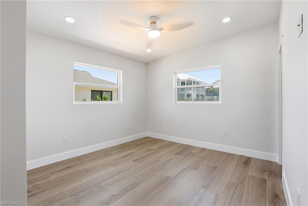 This room features sleek flooring, recessed lighting, and a ceiling fan - Virtually Edited Image