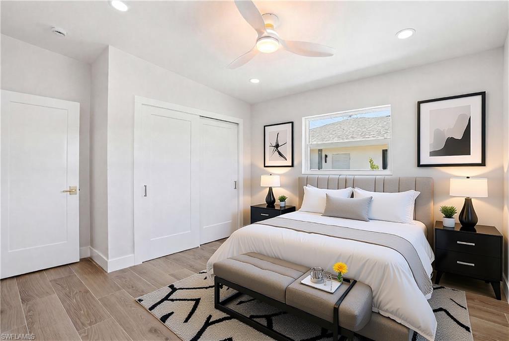 VIRTUALLY STAGED This bedroom features light wood-look flooring, a window providing natural light, and a ceiling fan with integrated lighting - Virtually Edited Image