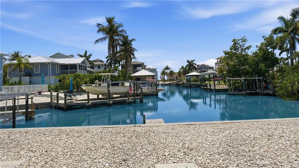 Waterfront property with private boat dock and lift, surrounded by tropical landscaping and palm trees - Virtually Edited Image