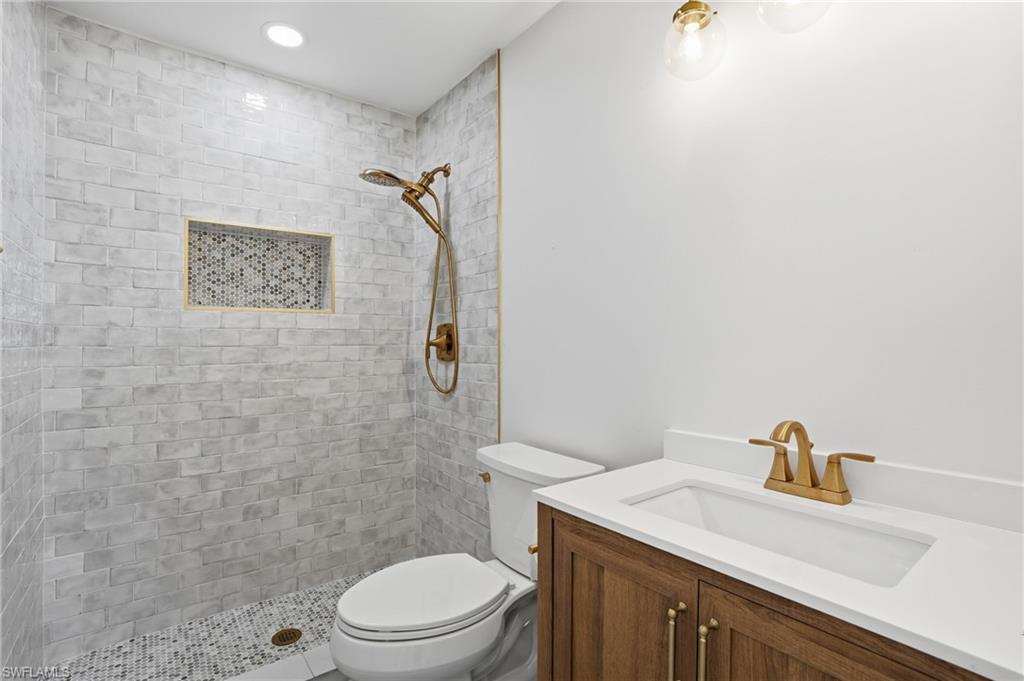 The bathroom features a walk-in shower with light-toned subway tiling and a mosaic-tiled niche - Virtually Edited Image