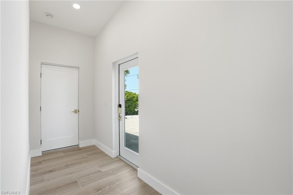 Entryway with light-colored tile flooring, white walls, and a recessed ceiling light - Virtually Edited Image