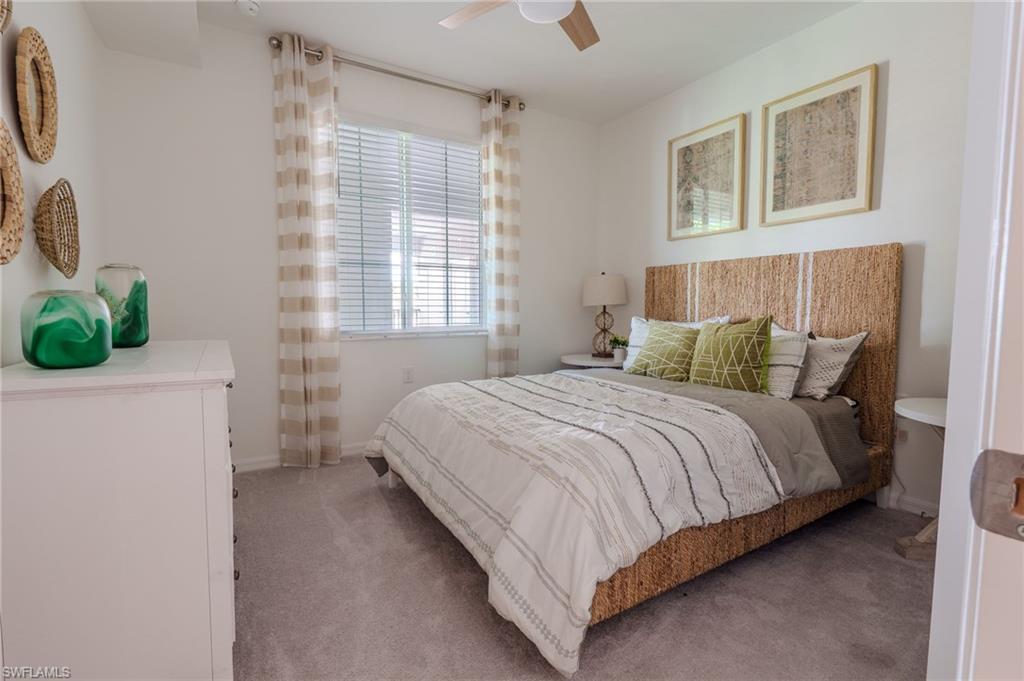 Neutral wall paint, light-colored carpeting, horizontal window blinds, and a ceiling fan with light