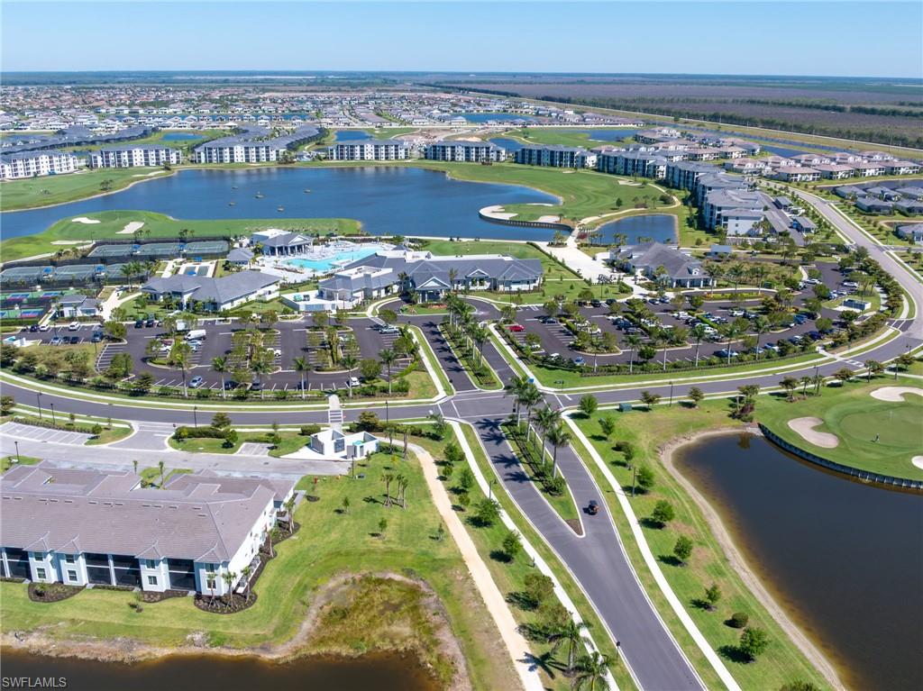 Expansive community featuring a central lake, golf course, multiple tennis courts, and a large resort-style swimming pool