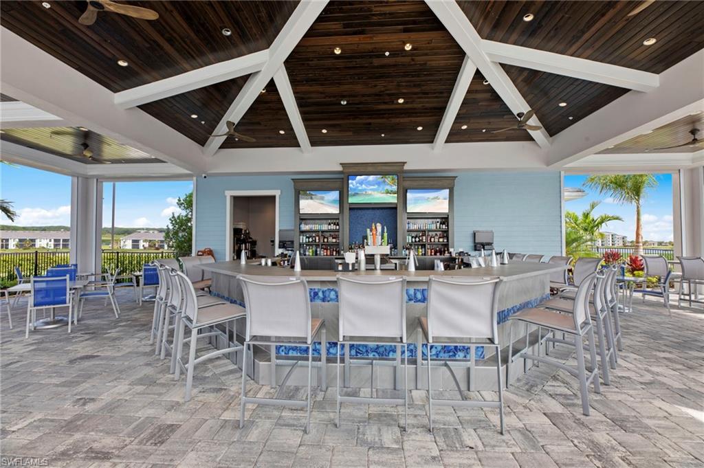 Outdoor bar with a vaulted wood-paneled ceiling, recessed lighting, and ceiling fans