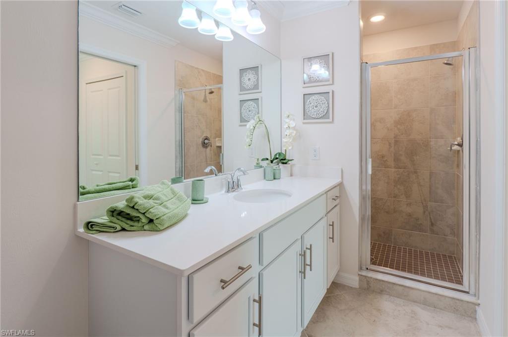 White vanity with a single basin sink, chrome faucet, and ample counter space