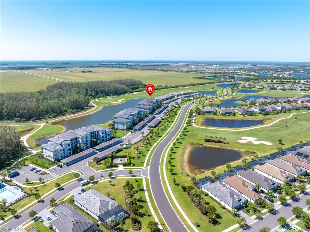 Aerial perspective of a structured community featuring multiple bodies of water and golf course elements