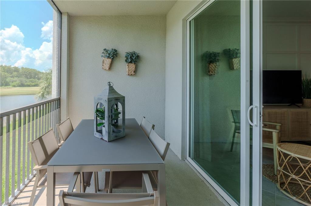 Screened balcony featuring a metal railing and a sliding glass door