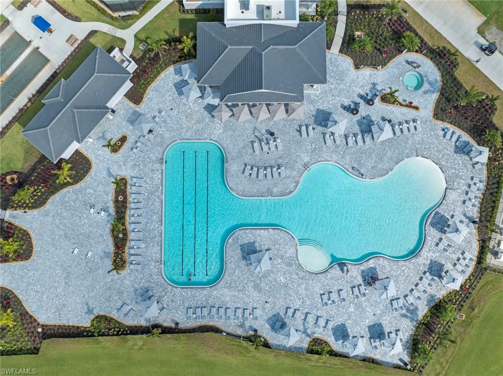 Expansive aquatic amenity featuring a large swimming pool, a custom-shaped leisure pool with a beach entry, and an integrated spa