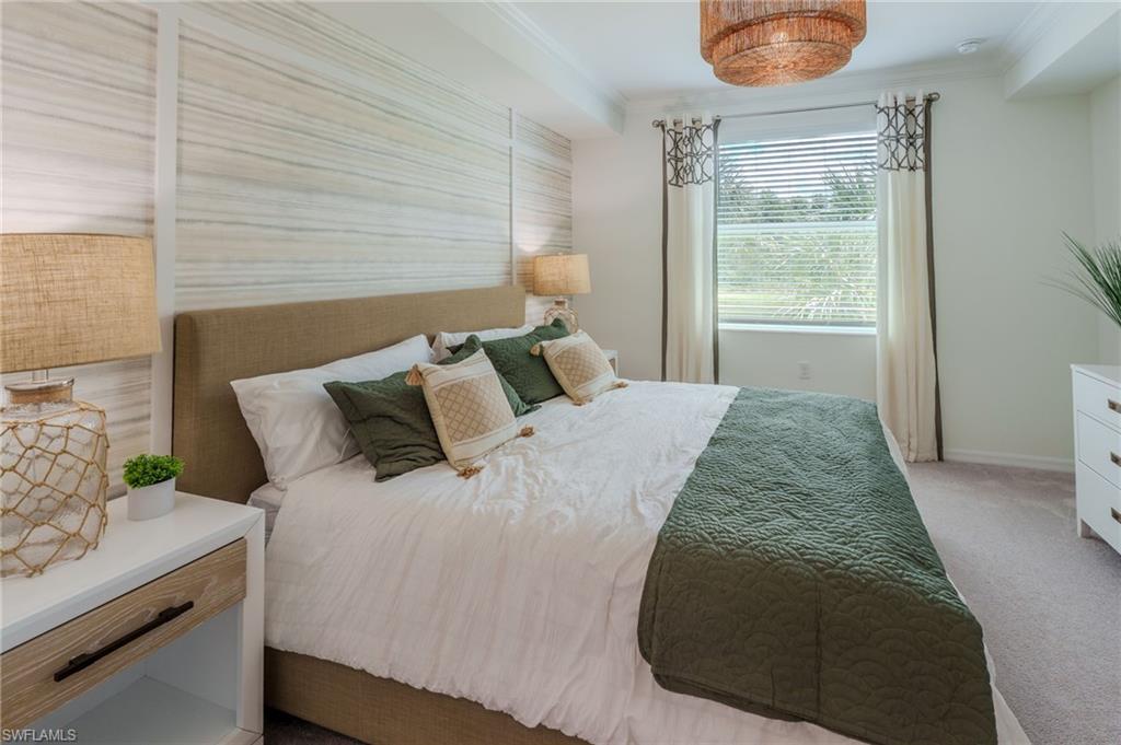 Textured accent wall, neutral carpeting, recessed ceiling, window with blinds, and a built-in ceiling light fixture