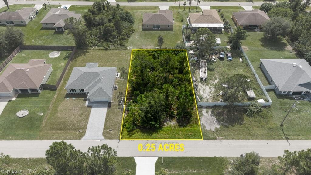 0.25-acre undeveloped parcel featuring mature trees, a clear street frontage, and surrounded by developed residential properties