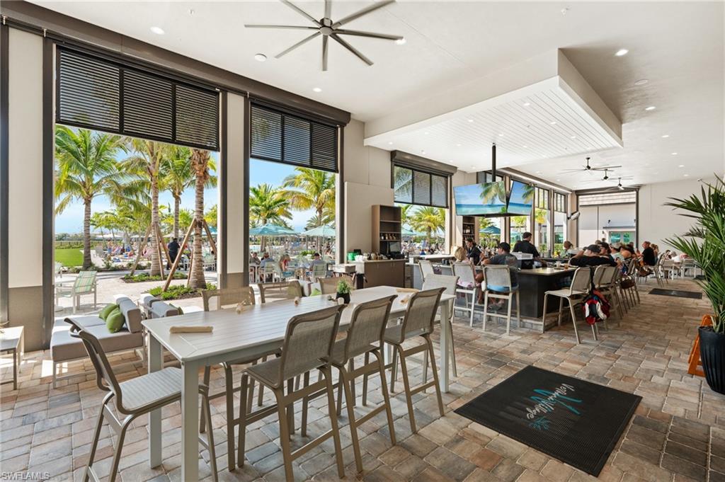 Spacious covered patio with paver flooring, built-in bar, and high ceilings