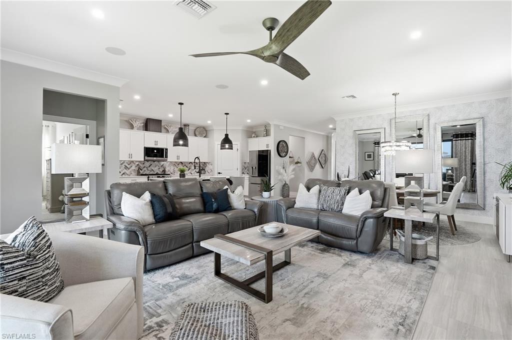 Open-concept living area featuring light wood-finish flooring, recessed ceiling lighting, and a ceiling fan