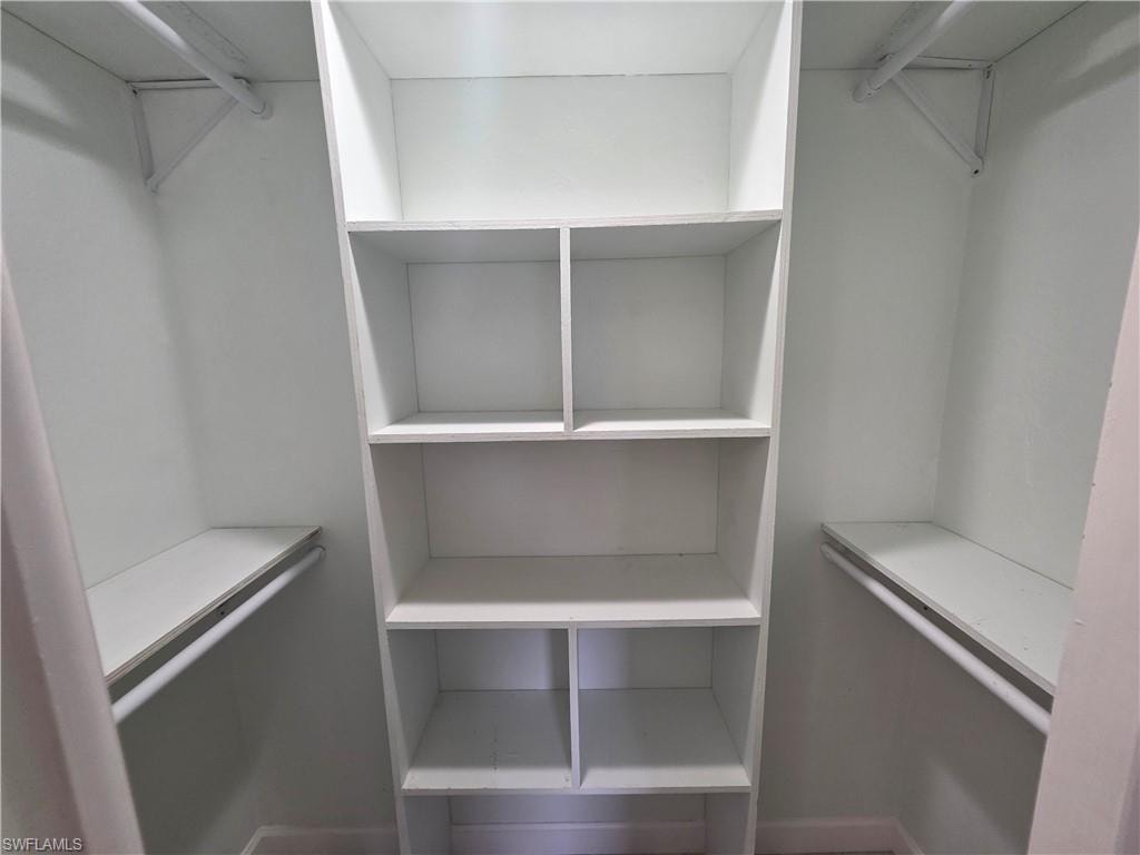 Built-in shelving unit with multiple cubbies, integrated hanging rods, and upper storage shelves