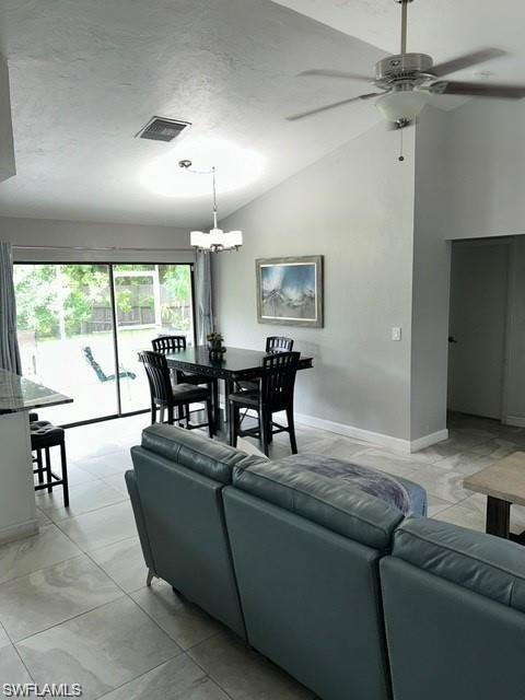 Vaulted ceiling with a ceiling fan, recessed lighting, and a chandelier