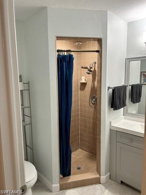 Tiled shower enclosure, single vanity with integrated sink, framed mirror, and light-toned wall paint