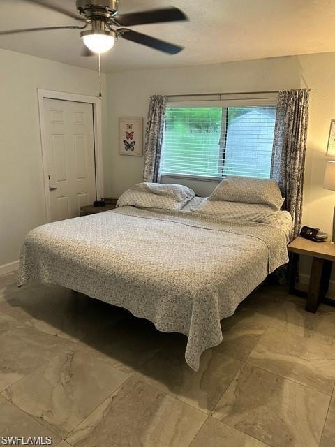 Neutral toned tile flooring, ceiling fan with integrated lighting, window with horizontal blinds, and a paneled door