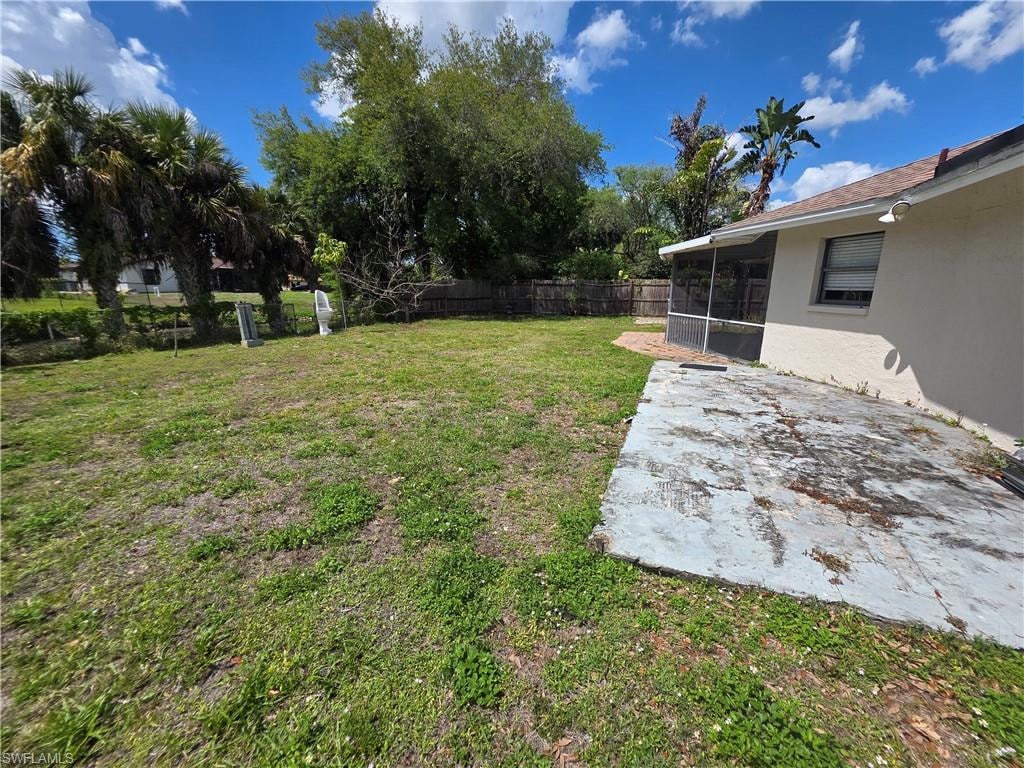 Expansive backyard featuring a screened patio and mature landscaping