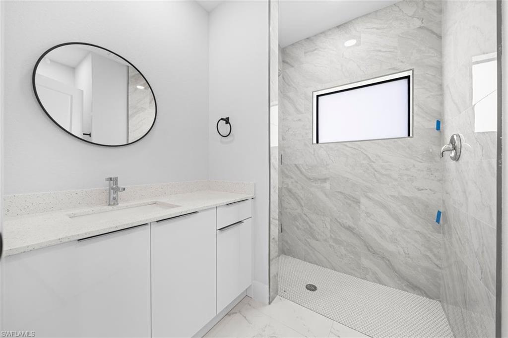 White floating vanity with an integrated sink, polished chrome faucet, and a large oval mirror
