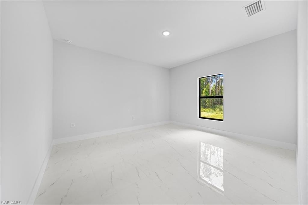 Recessed ceiling lighting, a single pane window, white walls, and polished white flooring