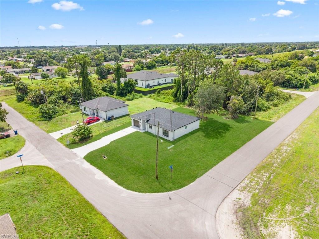 Single-story residence featuring a white exterior, dark shingle roof, attached garage, and a concrete driveway