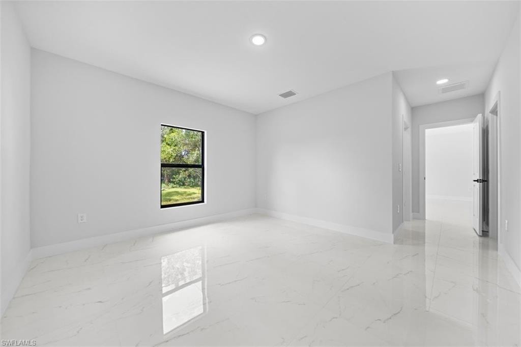 Polished tile flooring, recessed ceiling lighting, single pane window, and white wall finishes