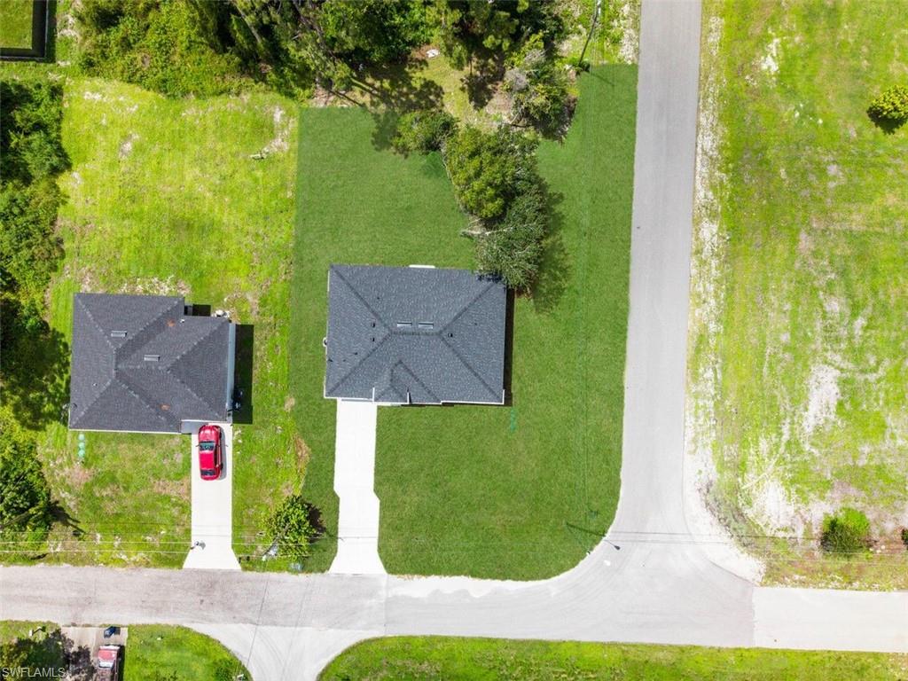 Detached single-story property featuring a dark-toned roof and a light-colored driveway