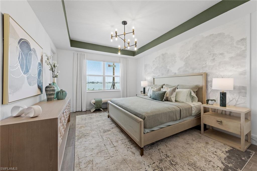 Tray ceiling with accent paint, modern chandelier, wood-finish flooring, ample natural light, and custom wall mural