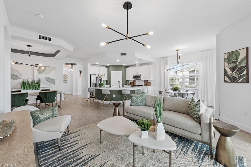 Open-concept living area featuring wood-finish flooring and a contemporary chandelier