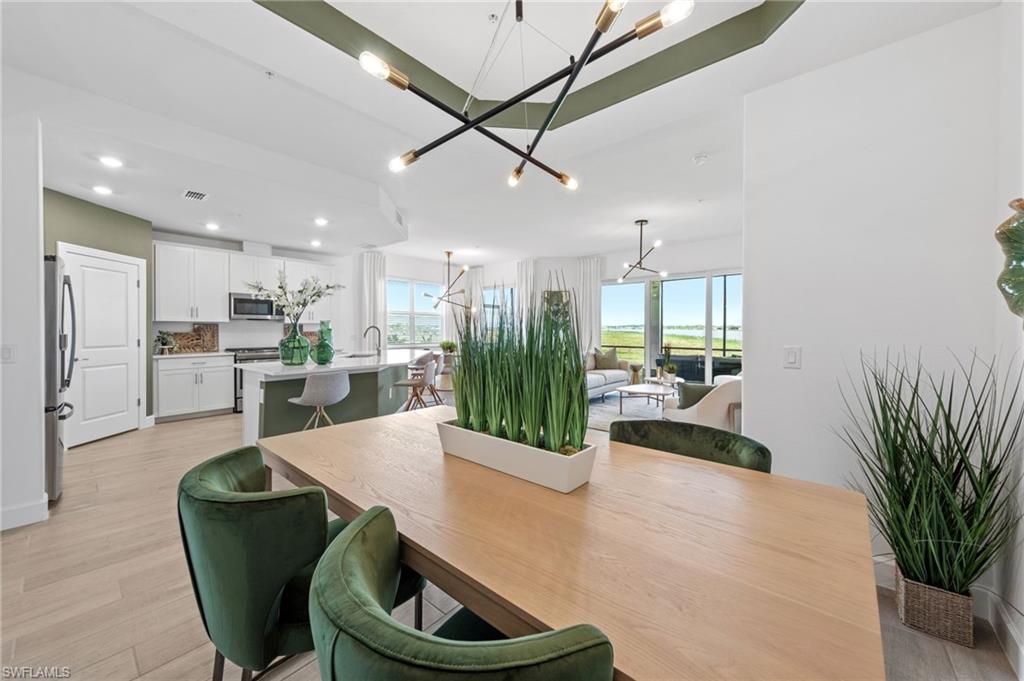 Open-concept living space with wood-finish flooring, a modern chandelier, and recessed lighting