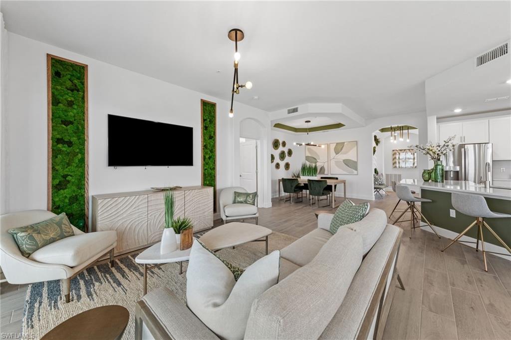 Open-concept living area featuring wood-finish flooring and integrated kitchen with stainless steel appliances