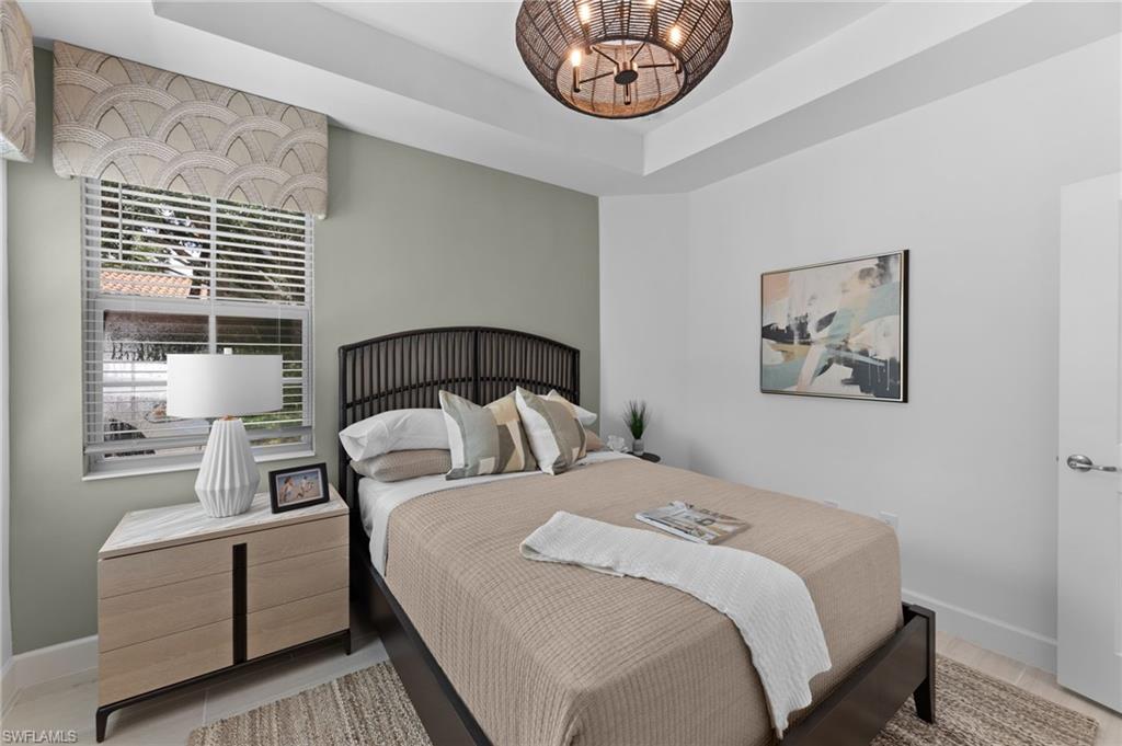 Tray ceiling, recessed lighting, window with blinds, light wood-finish flooring, and a unique woven light fixture