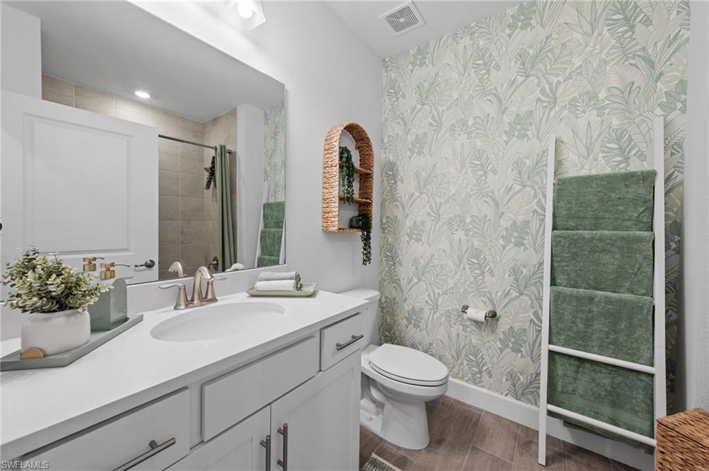 White vanity with an integrated sink, brushed nickel faucet, and under-cabinet storage