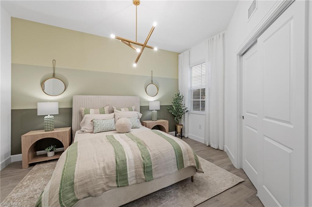 Ceiling-mounted multi-directional light fixture, light wood-finish flooring, window with blinds, and white panel doors