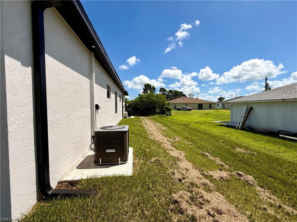 White stucco exterior with black gutters and a dark soffit