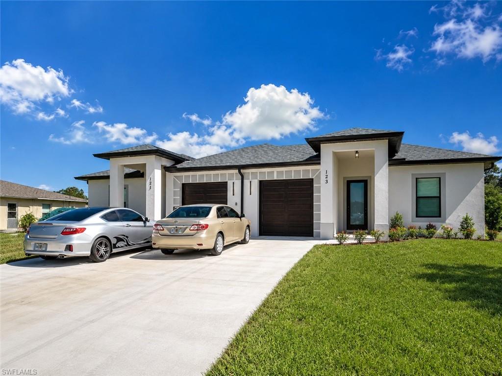 Open-concept kitchen with white cabinetry, stainless steel appliances, and a central island with a sink
