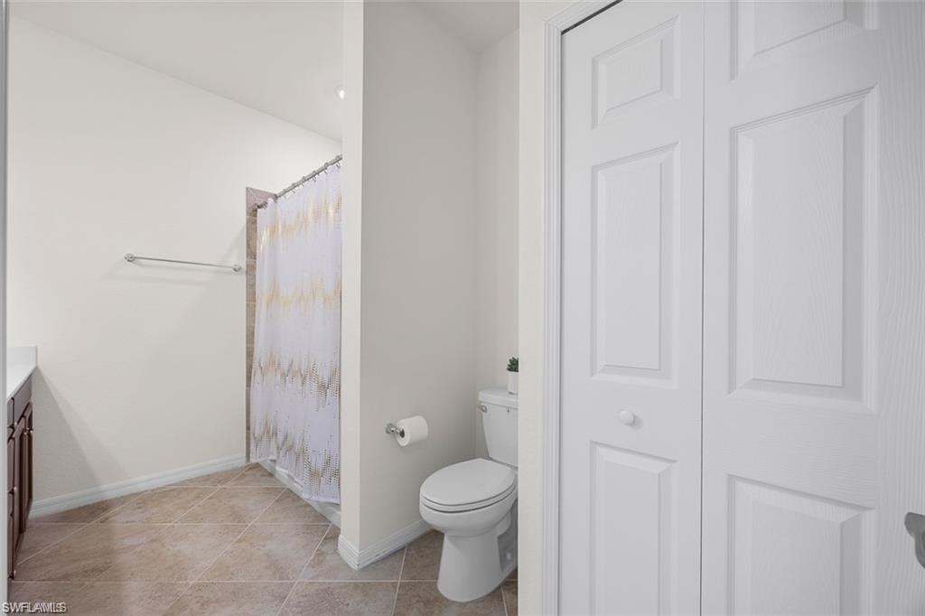 Tiled flooring with neutral tones, white walls, and a built-in shower